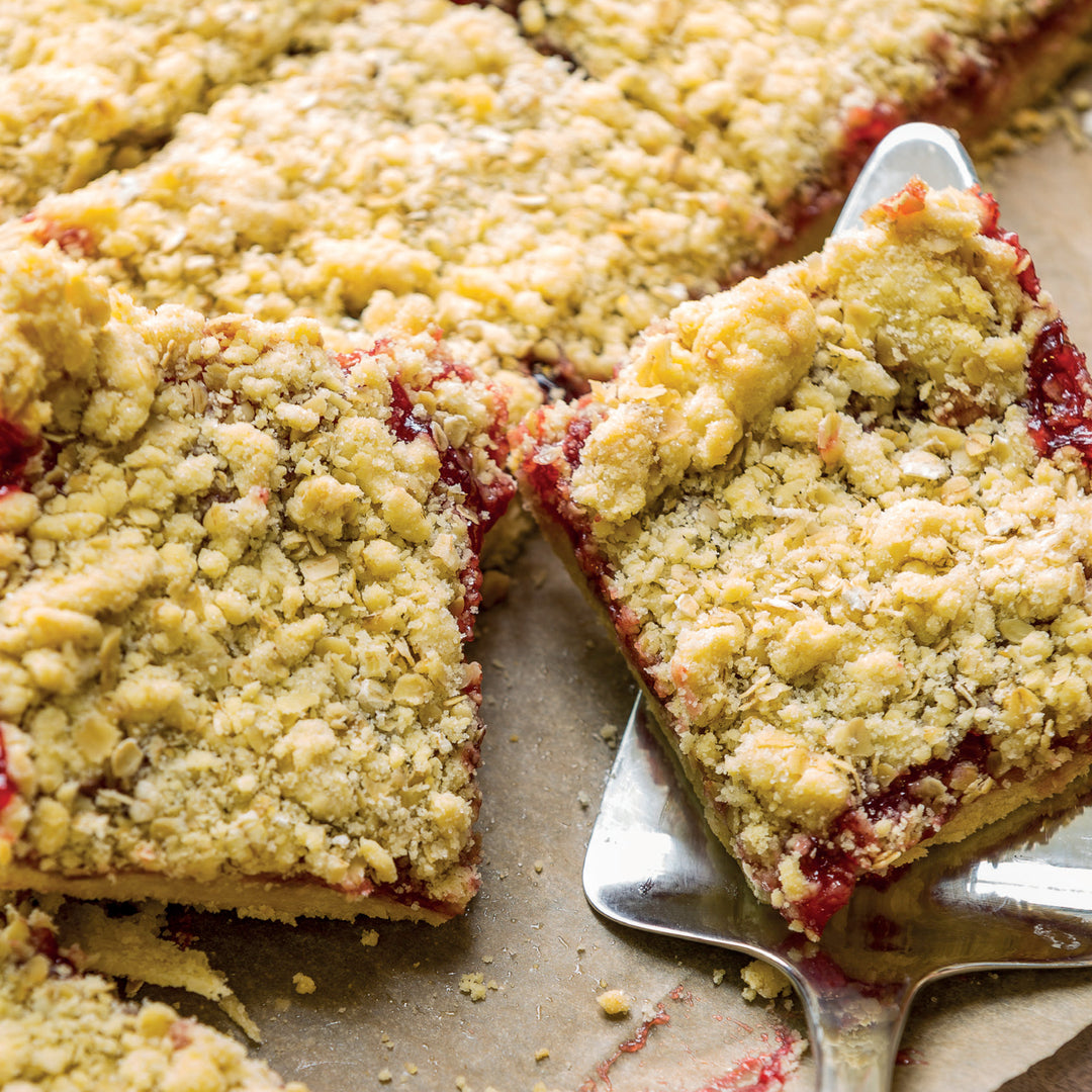 Rhubarb Crumble slice with Womersley Strawberry & Mint Vinegar on a tray.