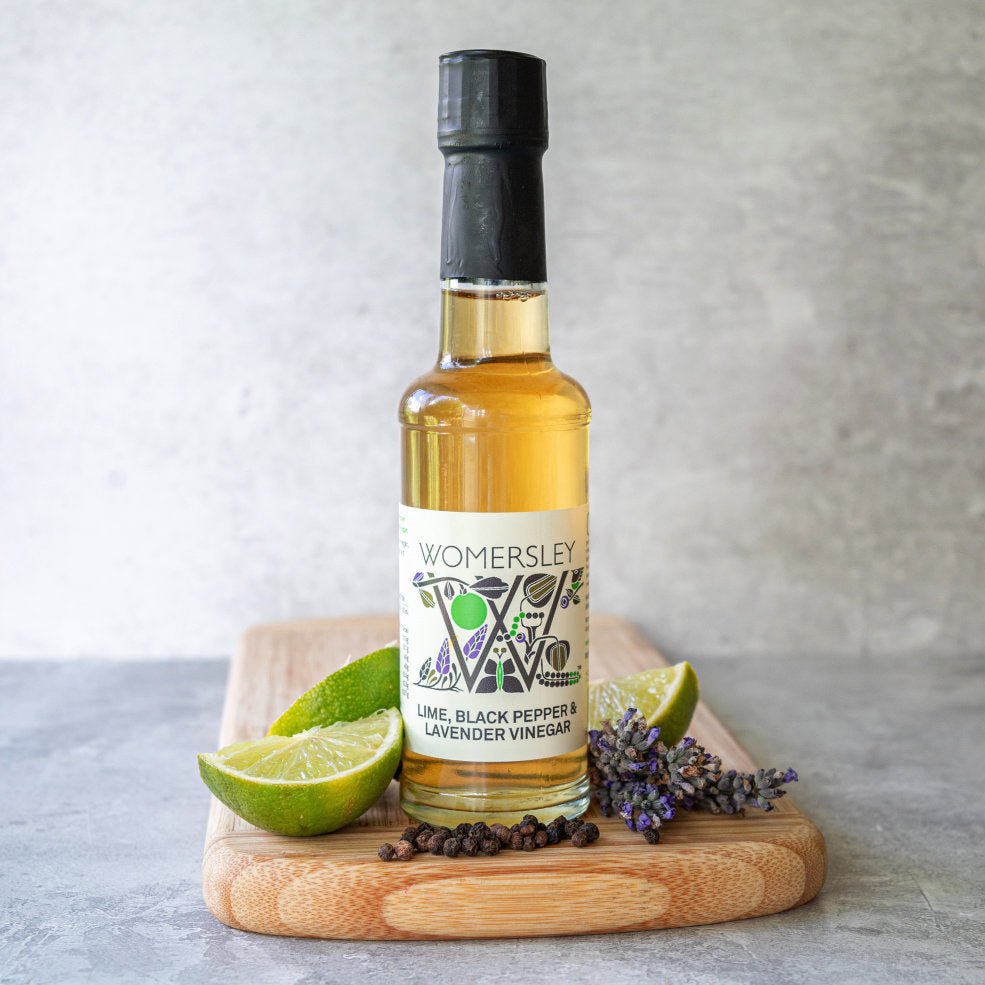Womersley Foods Lime Black Pepper and Lavender Vinegar 150ml bottle with fresh limes, black peppercorns and lavender
