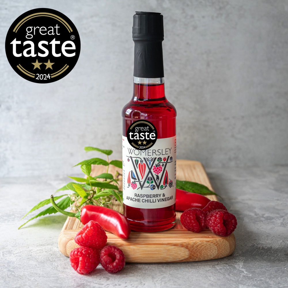 Womersley Foods Raspberry and Apache Chilli Vinegar 150ml bottle with fresh raspberries and chilli peppers - Great Taste Award 2024 winner