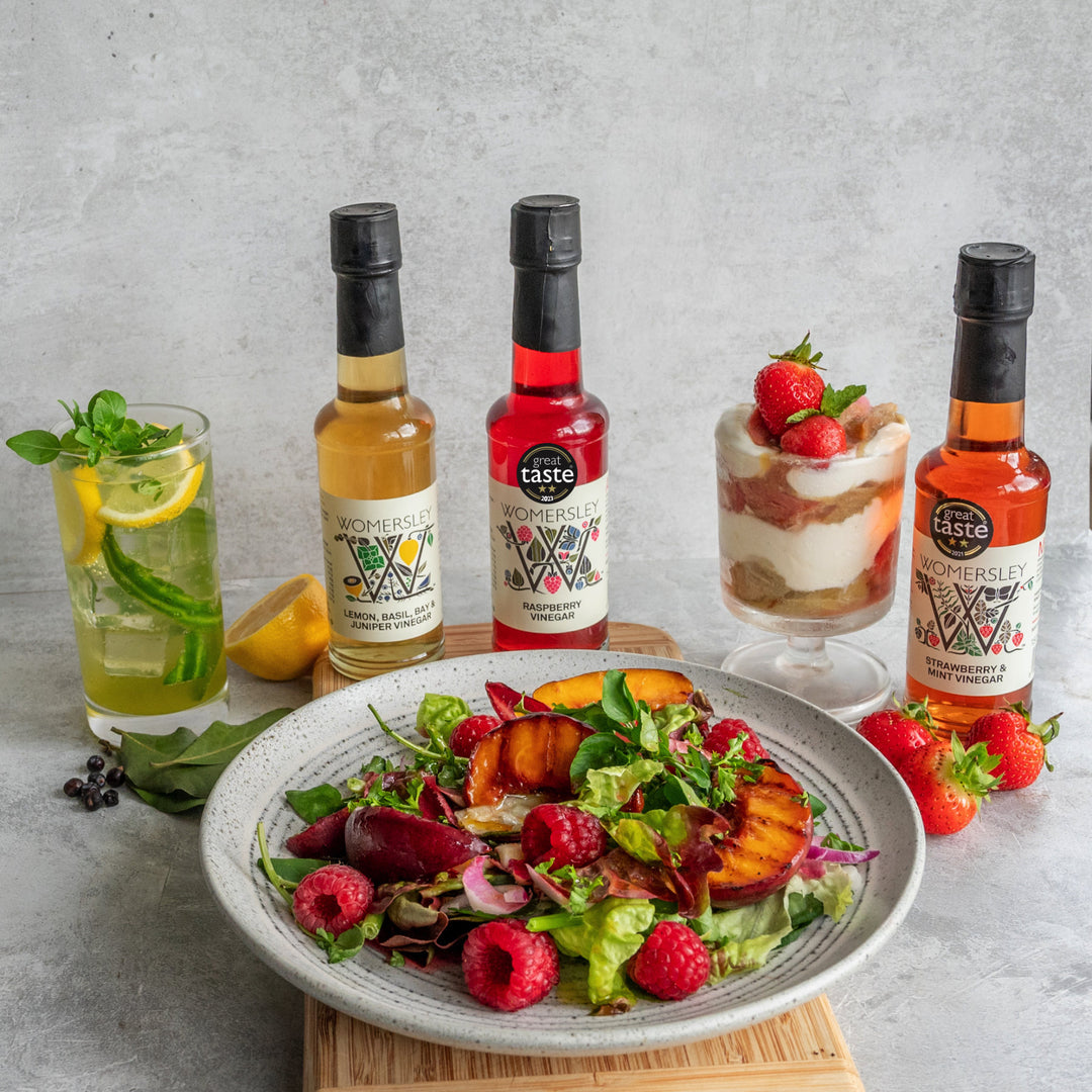 Three popular Womersley fruit & herb vinegars with salad on a plate, glass of ice lemon and glass of ice cream.