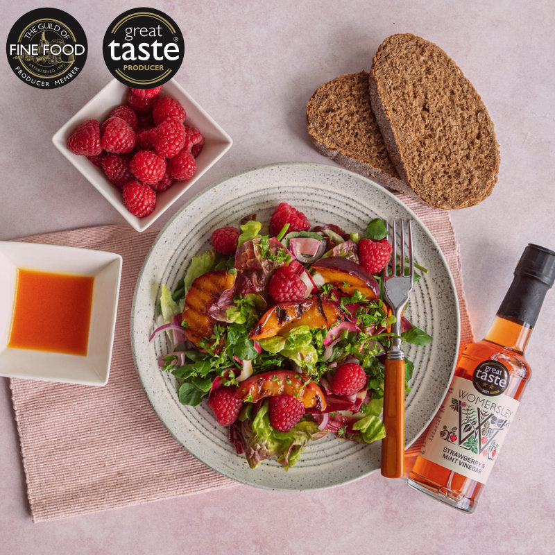 Image of Womersley Foods Strawberry and Mint Fruit  & Herb Vinegar lying beside a plate of delicious looking fruit salad  with Bread and Strawberry Sauce.